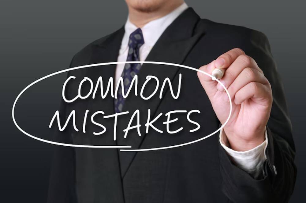 A man in a suit writes 'COMMON MISTAKES' visibly with a marker, emphasizing the importance of avoiding errors.